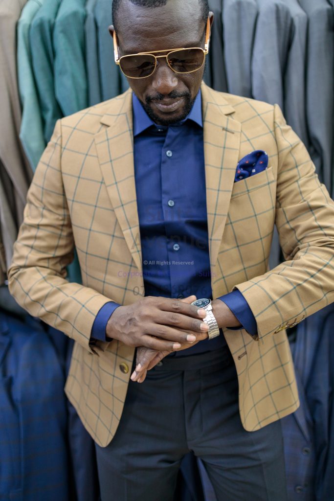 A model wearing a tan windowpane blazer with a navy shirt
